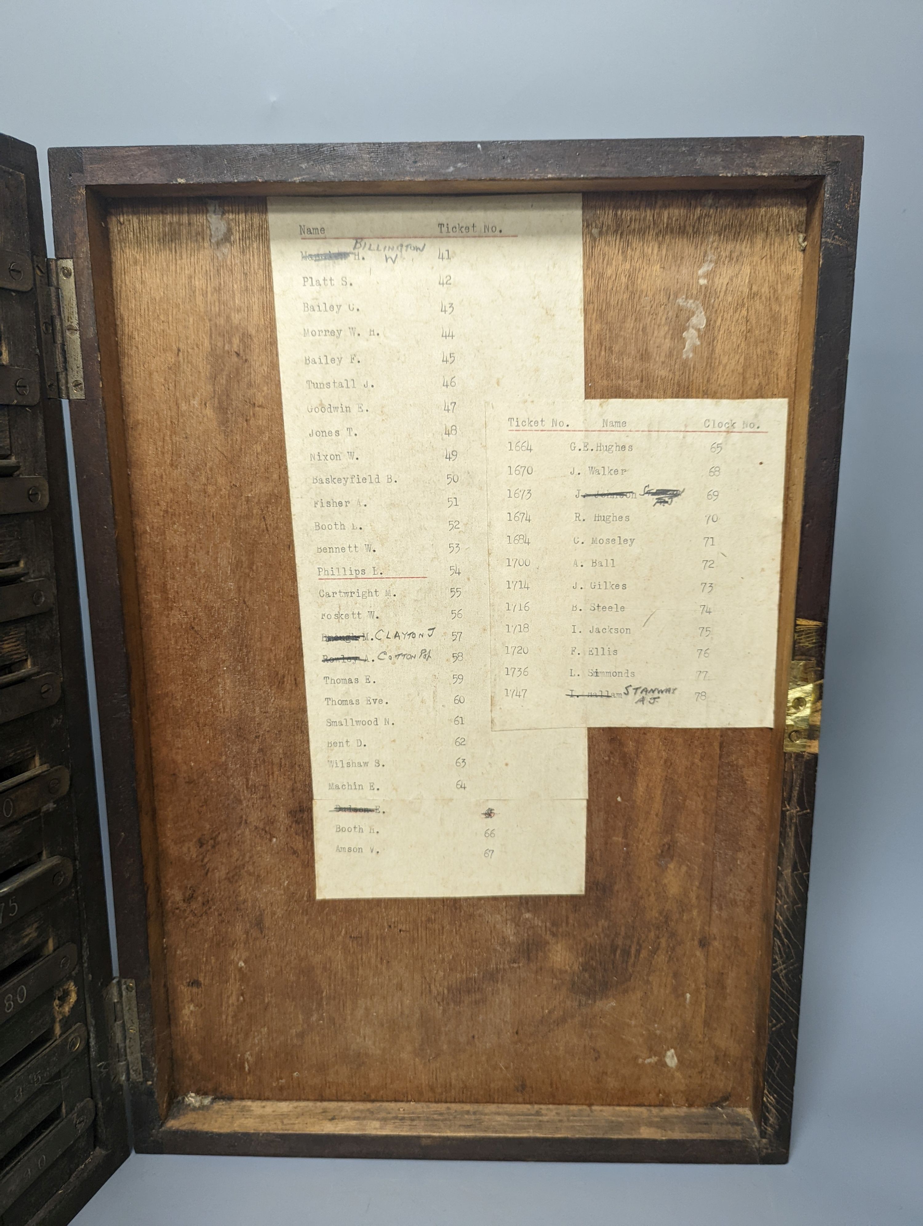 An early 20th century textile mill clocking in board with engraved numbered tokens